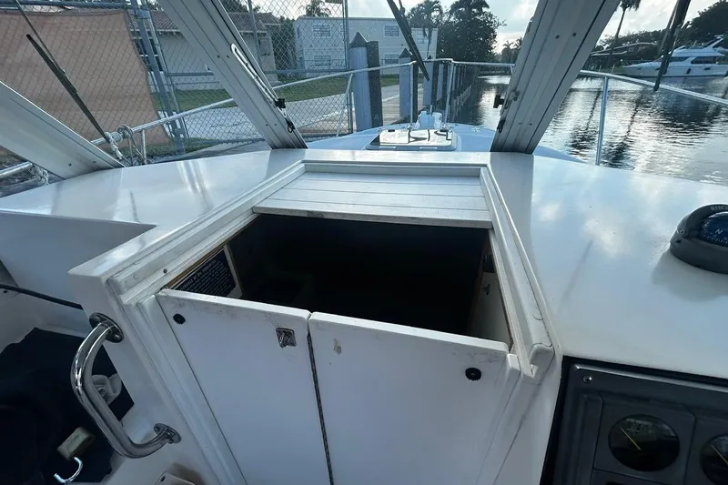 Slide: The Image of 2000 Albin 28 Tournament Express boat interior with open cabin hatch, docked by water. - 28