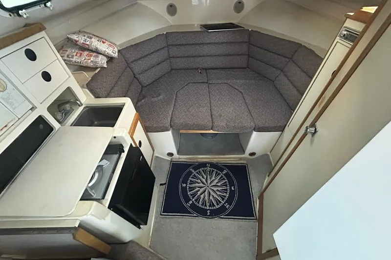 Slide: The Image of Interior of 2000 Albin 28 Tournament Express with cozy seating and compact kitchen area. - 29