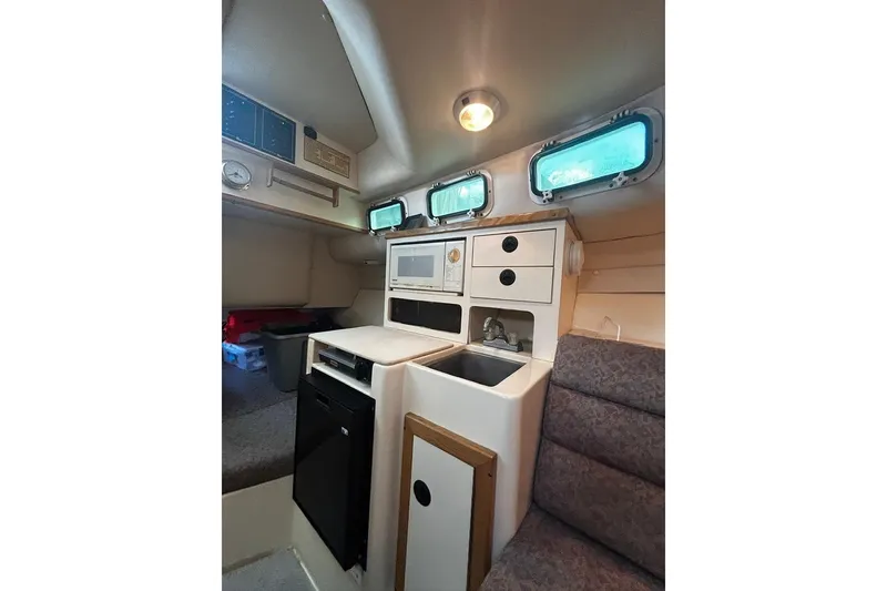 Slide: The Image of Interior of 2000 Albin 28 Tournament Express with kitchenette and seating area. - 30
