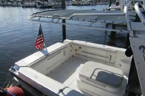Slide: The Image of 2000 Albin 28 Tournament Express boat docked, featuring spacious deck and American flag. - 5