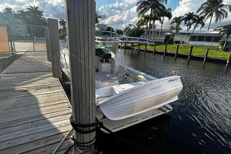 Slide: The Image of 2000 Albin 28 Tournament Express docked by a wooden pier, surrounded by palm trees. - 8