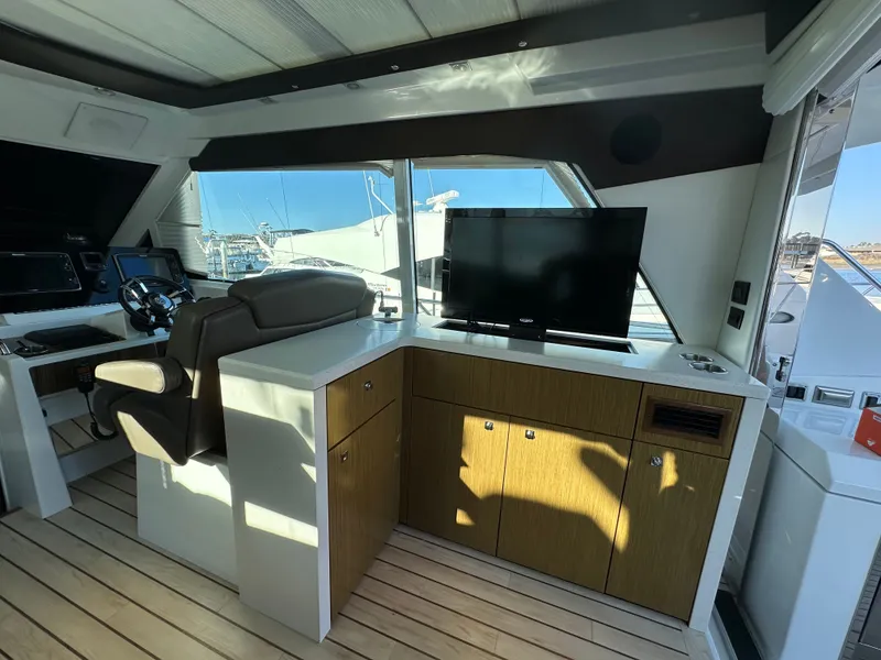 Slide: The Image of Interior of a 2014 Cruisers Yachts 48 Cantius with helm and TV. - 34