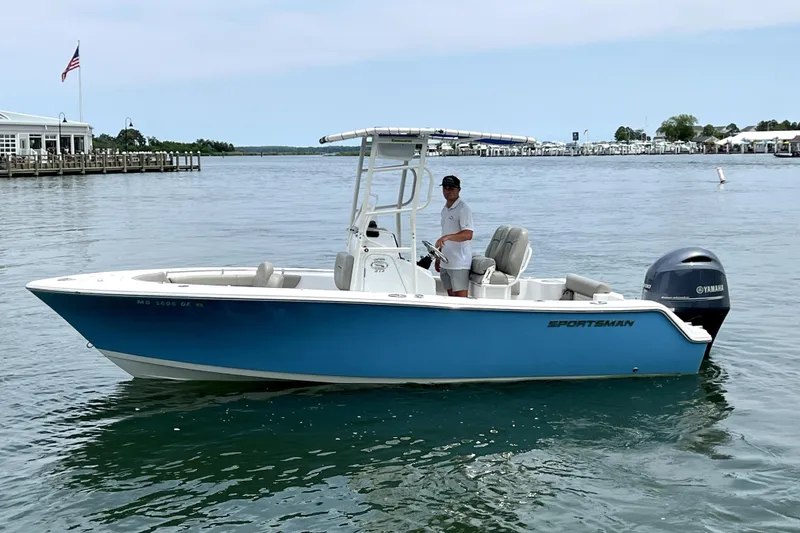 The Image of 2022 Sportsman Open 212 Center Console boat on calm water near a dock. - 0