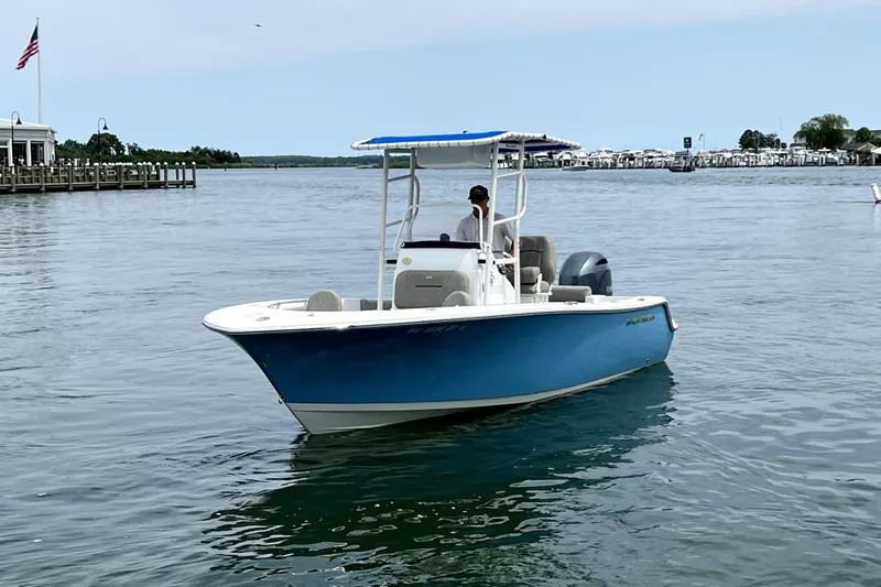 Slide: The Image of 2022 Sportsman Open 212 Center Console boat on calm water, featuring a blue hull. - 1