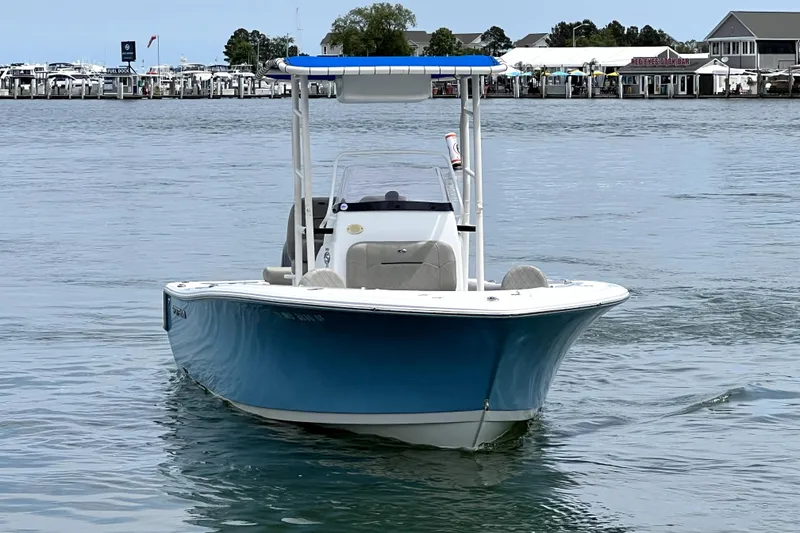 Slide: The Image of 2022 Sportsman Open 212 Center Console boat on calm water near a marina. - 14