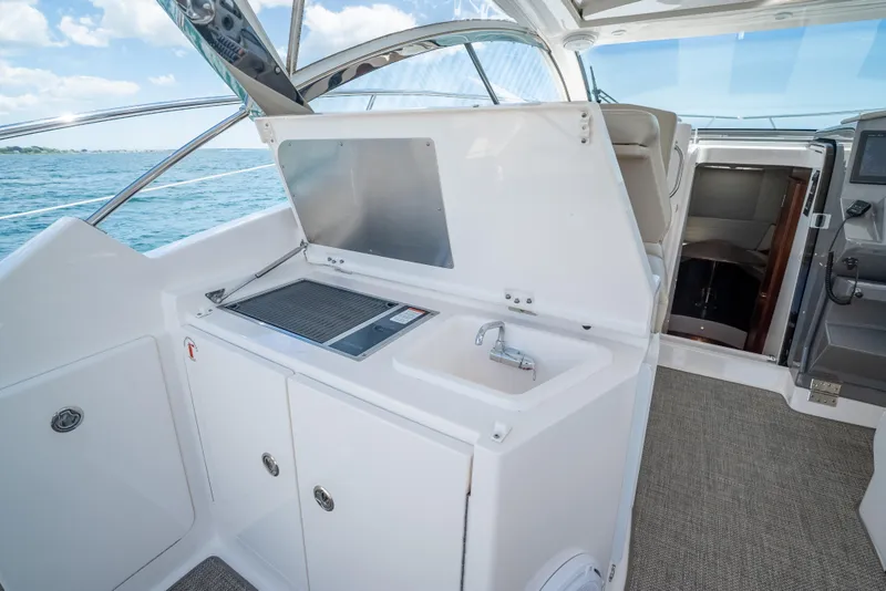 Slide: The Image of 2015 Pursuit SC 365i Sport Coupe yacht interior with kitchenette and ocean view. - 15