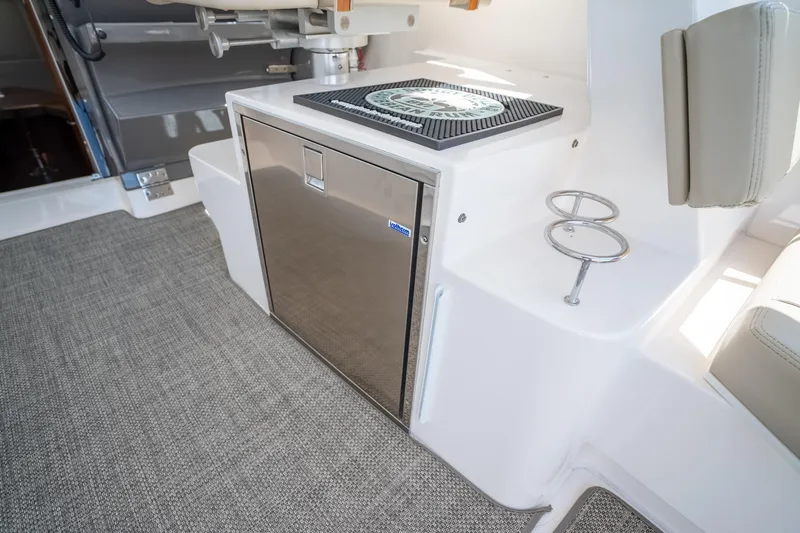 Slide: The Image of 2015 Pursuit SC 365i Sport Coupe interior with stainless steel fridge and cup holders. - 16