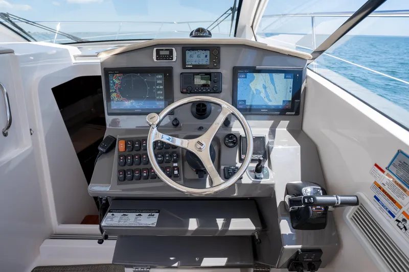 Slide: The Image of Helm of 2015 Pursuit SC 365i Sport Coupe with navigation screens and controls. - 21