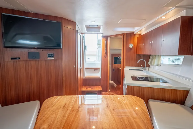 Slide: The Image of Interior of 2015 Pursuit SC 365i Sport Coupe with wood finish, kitchenette, and TV. - 27