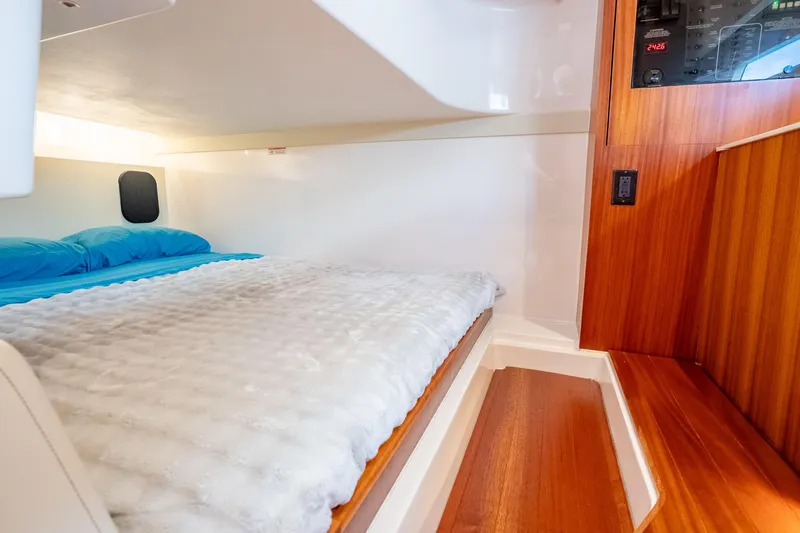 Slide: The Image of Interior cabin of 2015 Pursuit SC 365i Sport Coupe with cozy bed and wooden accents. - 30