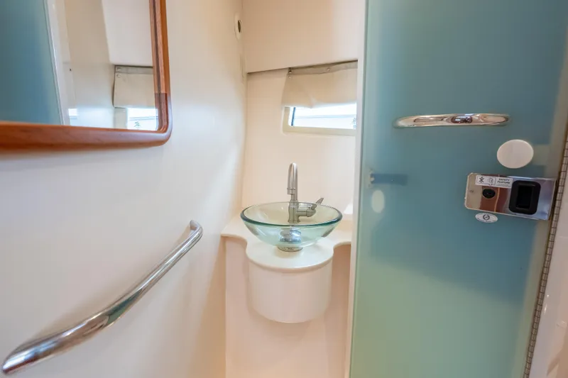 Slide: The Image of Modern bathroom interior on 2015 Pursuit SC 365i Sport Coupe yacht, featuring glass sink and sleek design. - 32