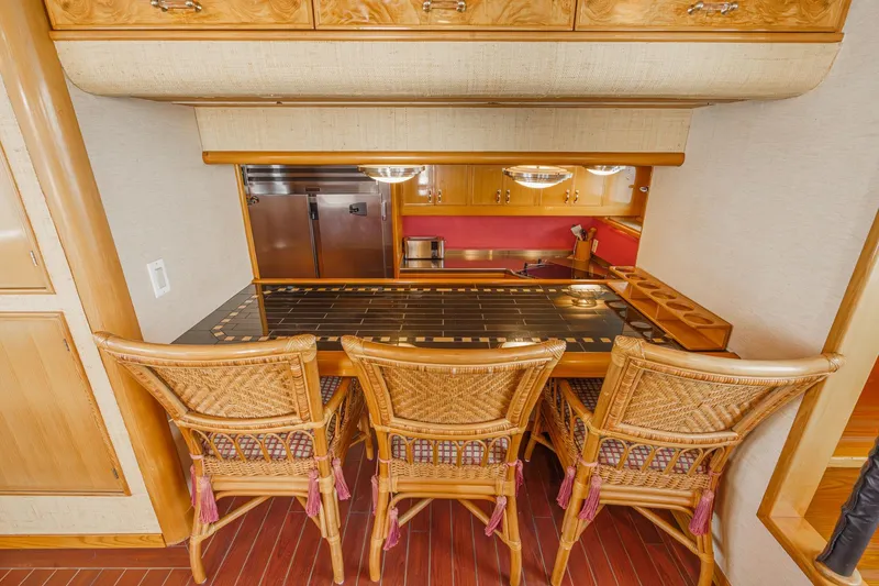Slide: The Image of Luxurious 1990 Seaton Long Range Cruiser kitchen with wicker chairs and elegant wood cabinetry. - 18