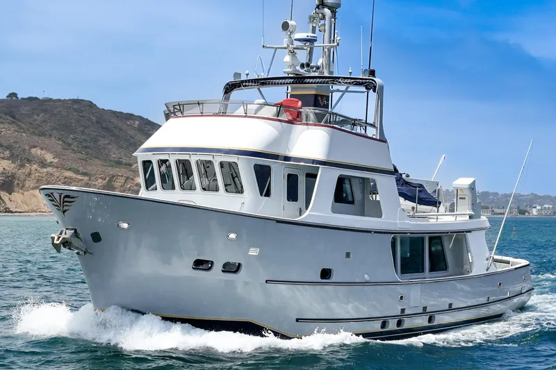 Slide: The Image of 1990 Seaton Long Range Cruiser yacht navigating coastal waters under clear blue skies. - 2