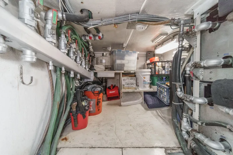 Slide: The Image of Engine room of a 1990 Seaton Long Range Cruiser with pipes and storage containers. - 35