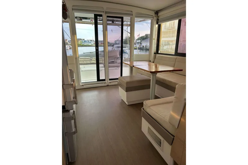 Slide: The Image of Interior of 2018 Bali 4.1 catamaran with seating and table, overlooking marina. - 10