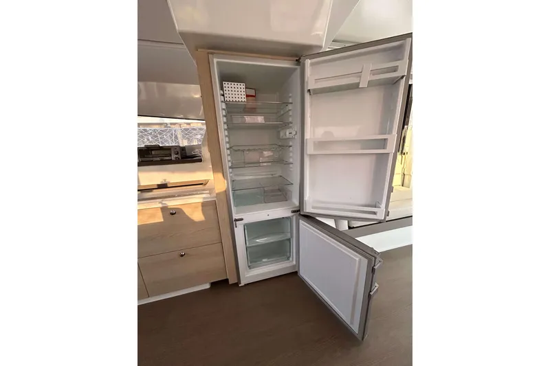 Slide: The Image of Open refrigerator in a Bali 4.1 model yacht, showcasing spacious interior shelves. - 12