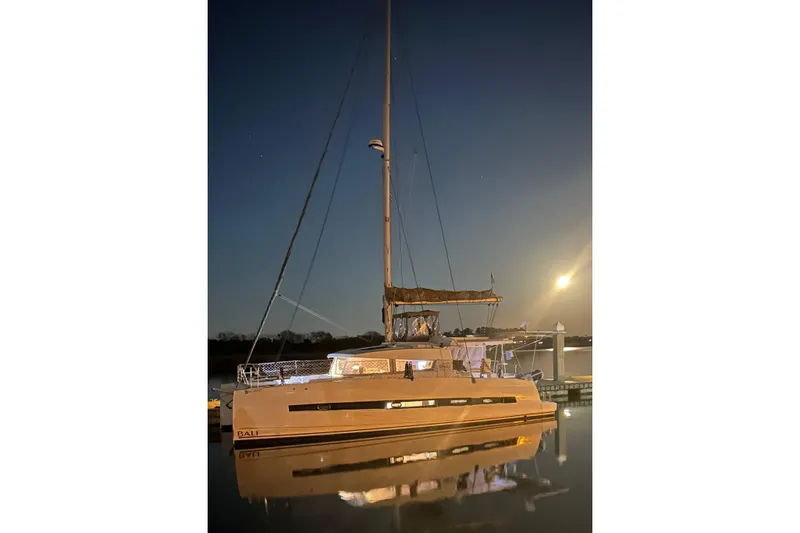 Slide: The Image of 2018 Bali 4.1 catamaran docked at night under moonlight. - 2