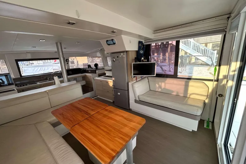 Slide: The Image of Interior of 2018 Bali 4.1 catamaran with modern seating and wooden table. - 9