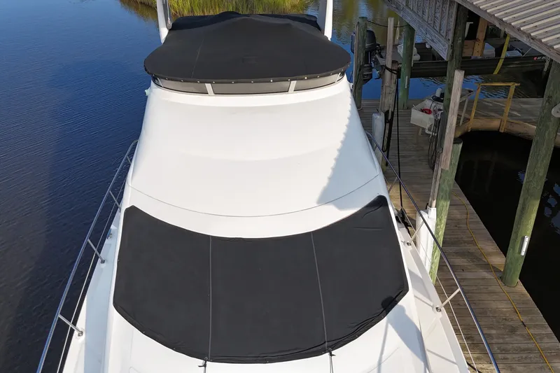 Slide: The Image of 2004 Sea Ray 420 Sedan Bridge yacht docked, covered in black canvas. - 3