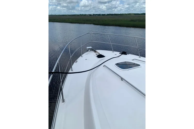 Slide: The Image of 2004 Sea Ray 420 Sedan Bridge yacht on calm water, showcasing sleek deck design. - 12
