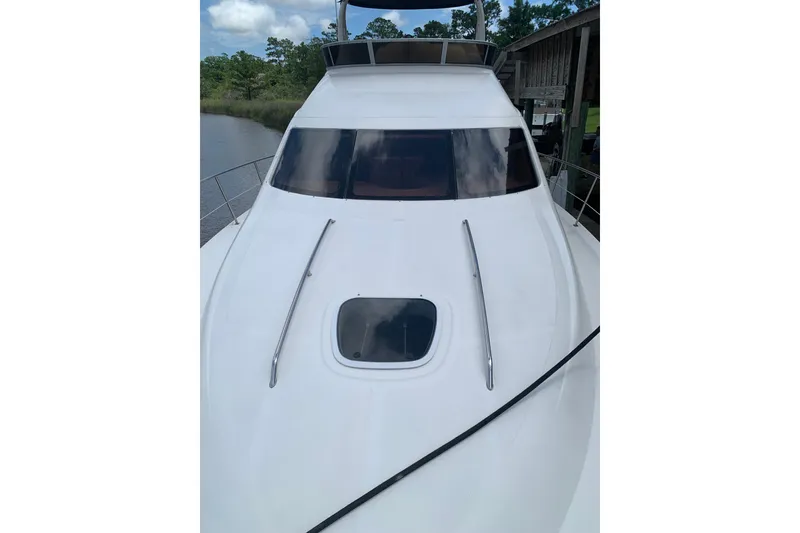 Slide: The Image of 2004 Sea Ray 420 Sedan Bridge yacht docked by a serene riverside. - 17