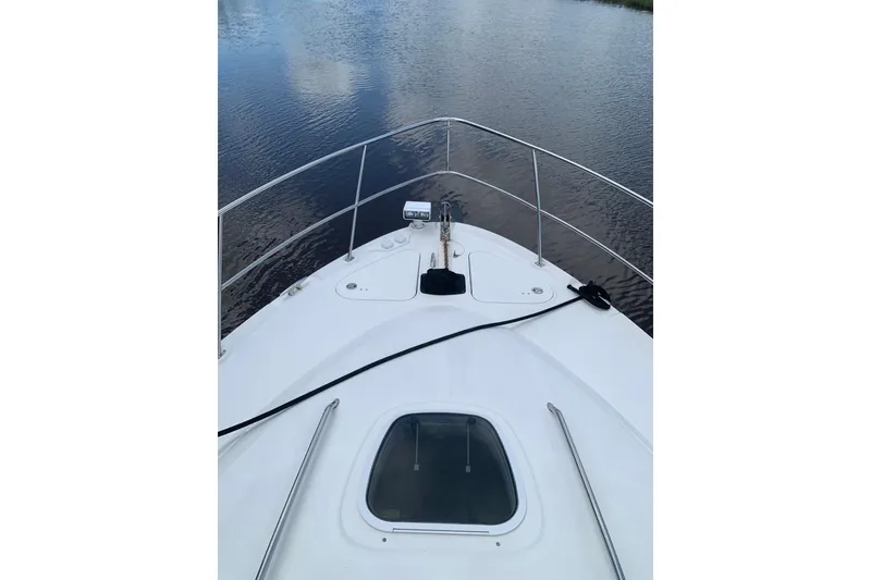 Slide: The Image of Bow view of 2004 Sea Ray 420 Sedan Bridge on calm water. - 18
