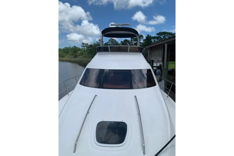 Slide: The Image of 2004 Sea Ray 420 Sedan Bridge yacht docked under a blue sky. - 2