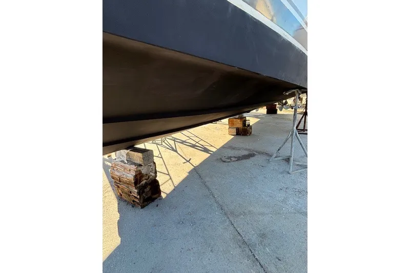 Slide: The Image of 2004 Sea Ray 420 Sedan Bridge hull on dry dock, supported by blocks and stands. - 99
