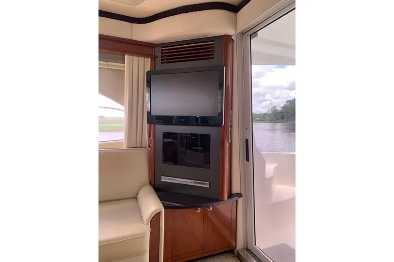Slide: The Image of Interior of 2004 Sea Ray 420 Sedan Bridge with TV and scenic water view. - 29