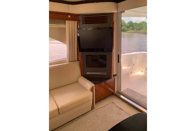 Slide: The Image of Interior of 2004 Sea Ray 420 Sedan Bridge with TV, sofa, and water view. - 31