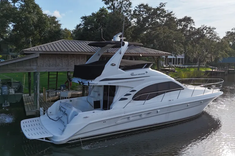 Slide: The Image of 2004 Sea Ray 420 Sedan Bridge yacht docked by a wooden boathouse. - 5