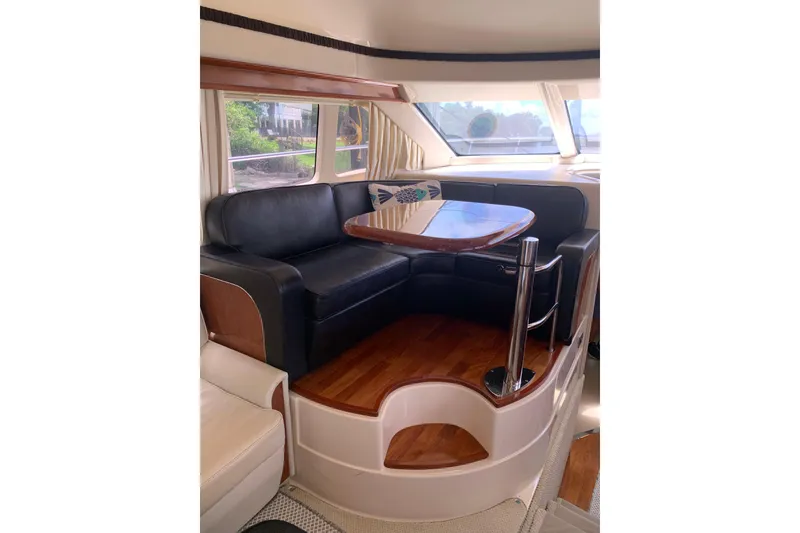 Slide: The Image of Luxurious interior of 2004 Sea Ray 420 Sedan Bridge with elegant seating and table. - 34