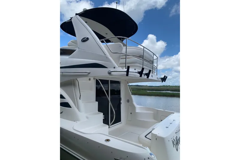 Slide: The Image of 2004 Sea Ray 420 Sedan Bridge yacht with sleek design, docked by a serene waterway. - 4