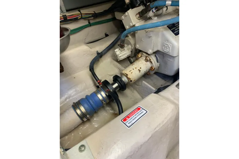 Slide: The Image of Engine compartment of a 2004 Sea Ray 420 Sedan Bridge with visible hoses and components. - 43
