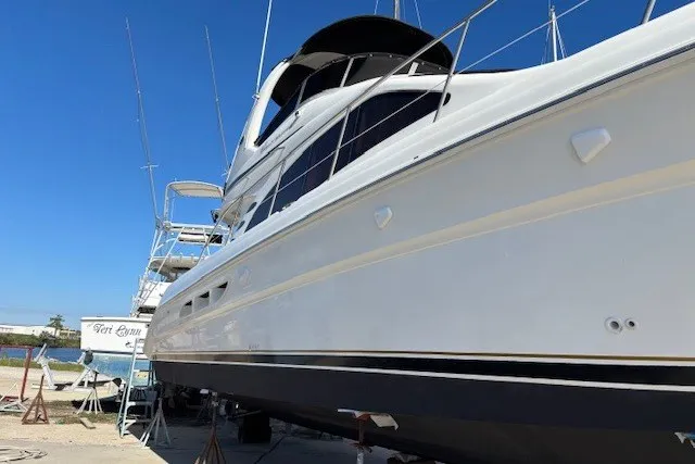 Slide: The Image of 2004 Sea Ray 420 Sedan Bridge yacht on dry dock under clear blue sky. - 109