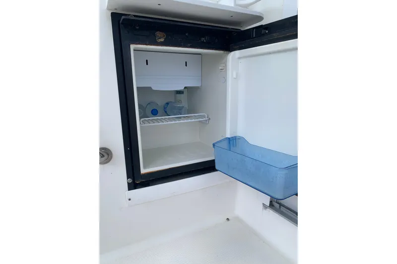 Slide: The Image of Open mini fridge on 2004 Sea Ray 420 Sedan Bridge yacht, containing water bottles. - 49
