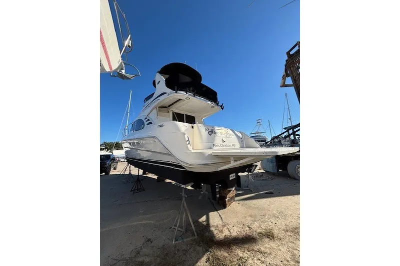 Slide: The Image of 2004 Sea Ray 420 Sedan Bridge yacht on dry dock under clear blue sky. - 108