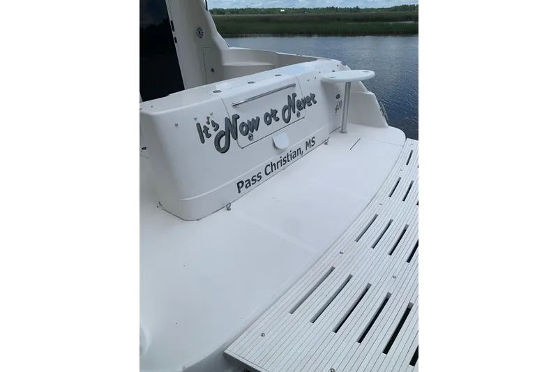 Slide: The Image of 2004 Sea Ray 420 Sedan Bridge boat with "It's Now or Never" text, docked in Pass Christian, MS. - 6