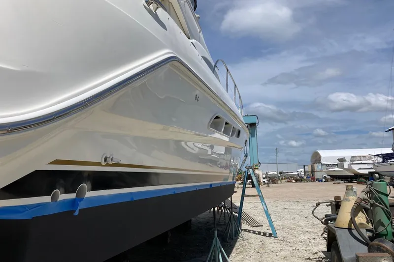 Slide: The Image of 2004 Sea Ray 420 Sedan Bridge yacht on dry dock under a clear blue sky. - 61
