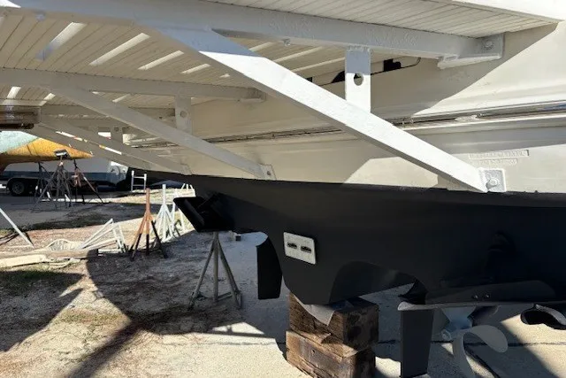 Slide: The Image of 2004 Sea Ray 420 Sedan Bridge boat hull on dry dock, supported by wooden blocks. - 84
