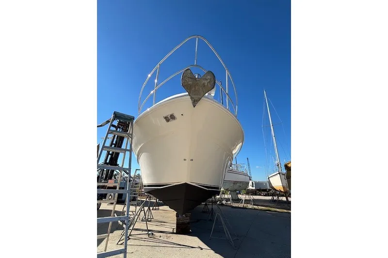 Slide: The Image of 2004 Sea Ray 420 Sedan Bridge yacht on dry dock under clear blue sky. - 105