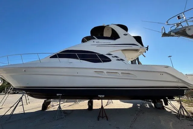 Slide: The Image of 2004 Sea Ray 420 Sedan Bridge yacht on stands under clear blue sky. - 107
