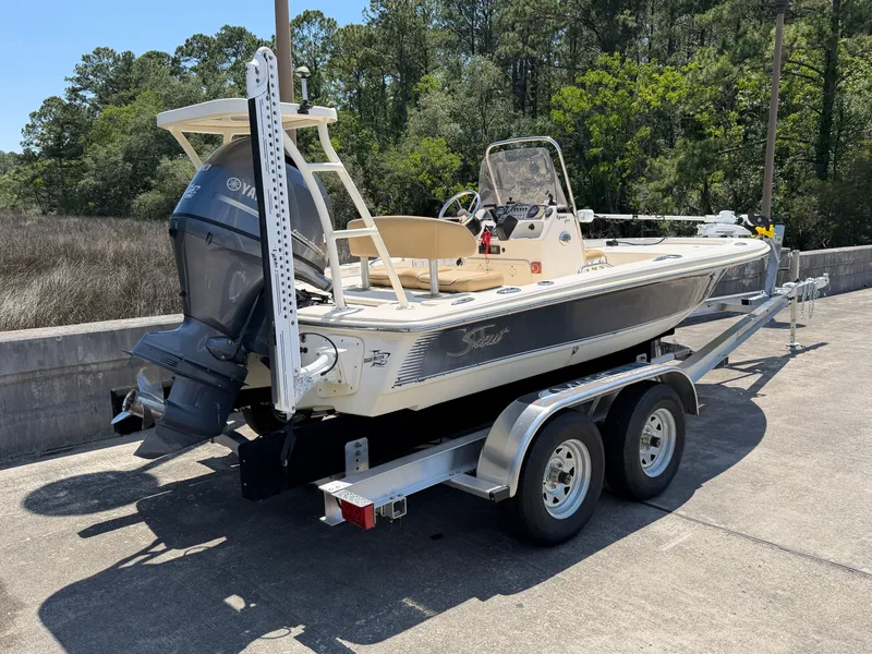 Slide: The Image of 2019 Scout 177 Sport boat parked on trailer outdoors. - 1