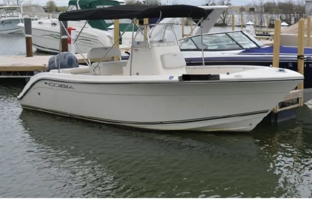 Slide: The Image of 2015 Cobia 201 Center Console boat docked on water. - 1