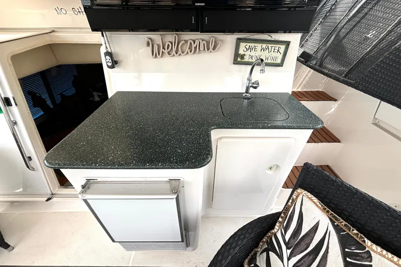 Slide: The Image of 1999 Silverton 453 Motor Yacht interior with kitchenette, sink, and decorative signs. - 12