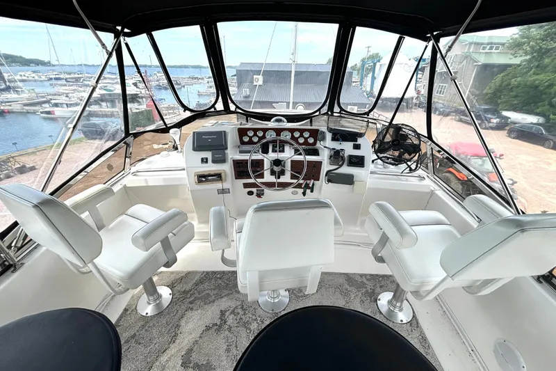 Slide: The Image of Interior view of 1999 Silverton 453 Motor Yacht helm with marina backdrop. - 15