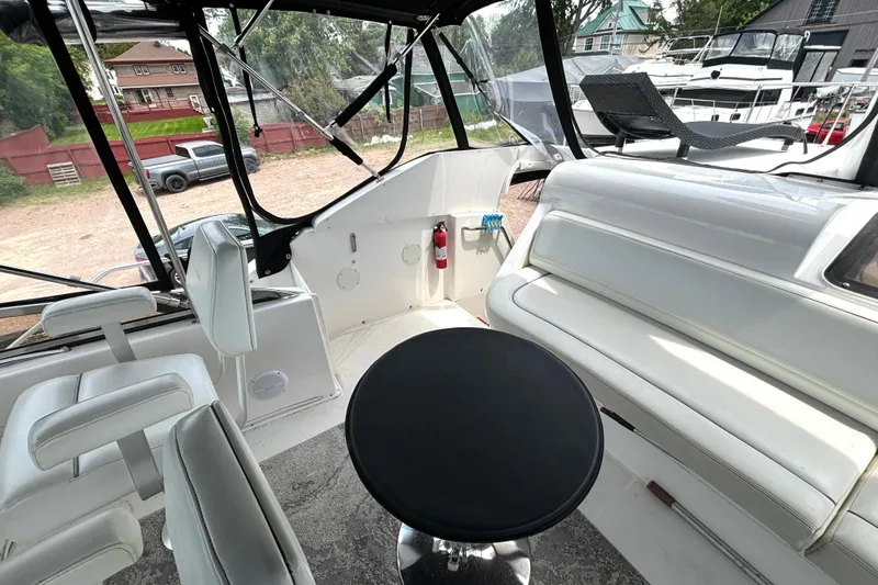 Slide: The Image of Interior view of a 1999 Silverton 453 Motor Yacht with white seating and a black table. - 16