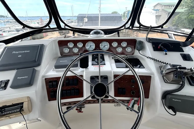 Slide: The Image of 1999 Silverton 453 Motor Yacht helm with Raymarine navigation, gauges, and steering wheel. - 18
