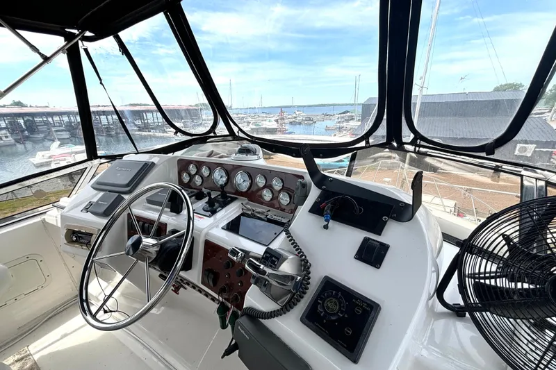 Slide: The Image of Cockpit view of 1999 Silverton 453 Motor Yacht with marina in background. - 19