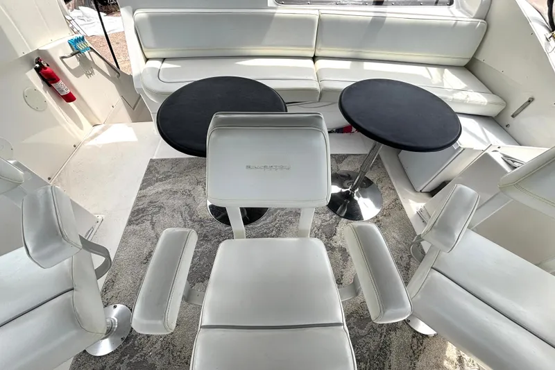 Slide: The Image of Interior of 1999 Silverton 453 Motor Yacht with white seating and black tables. - 27